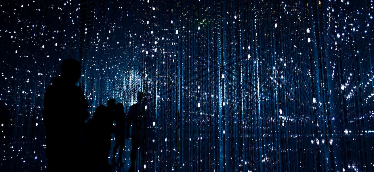 Several people standing within a light installation