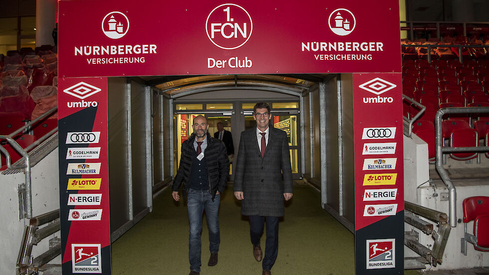 Two men in business outfits entering Nuremberg's football stadium