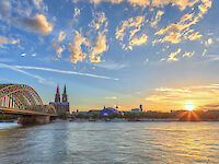Blick auf den Kölner Dom und die Hohenzollernbrücke bei Sonnenuntergang, shutterstock/Noppasin Wongchum