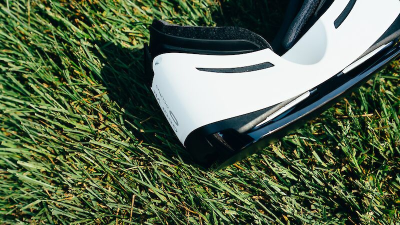 A pair of virtual reality glasses lies on the grass