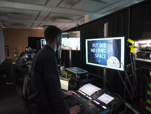 Ein Mann vor einer großen Tastatur und einem Monitor im Backstage-Bereich des Streaming-Studios.