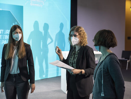 Katharina Dienes, Julia Hachenthal and Birgit Pacher in conversation. All three are wearing mouth guards.