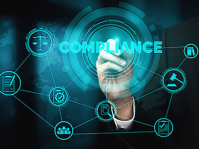 Auf einem Bildschirm steht das Wort "Compliance", darum herum sind verschiedene Logos platziert