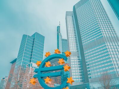 The Euro-Sign in front of several high-rise buildings.