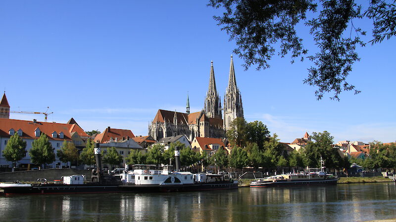 Blick auf die Stadt Regensburg mit Dom im Hintergrund, im Vordergrund der Fluss Donau.