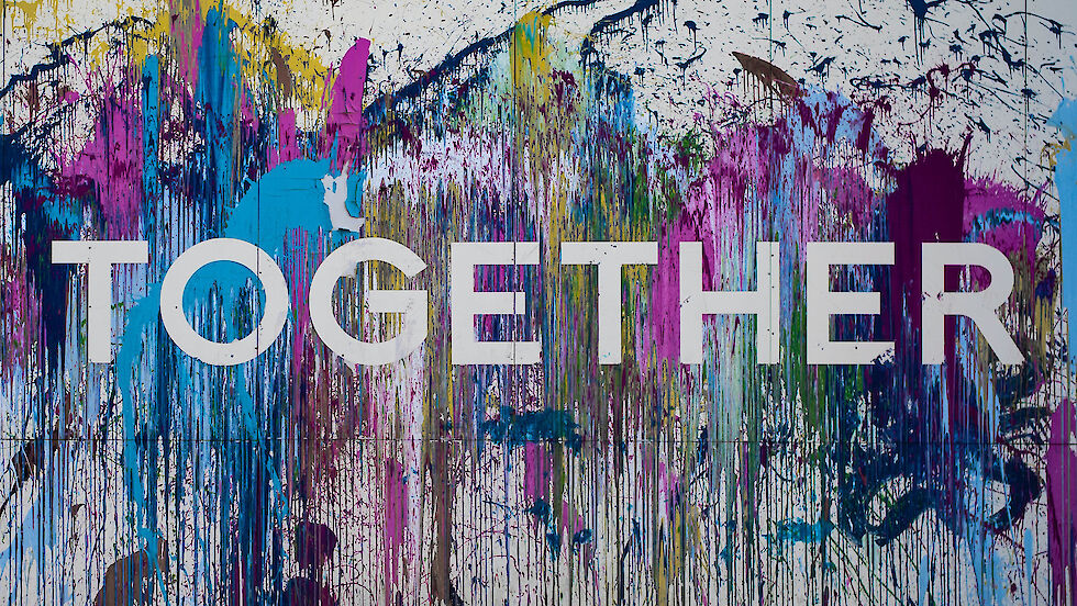 Wort "Together" auf einer Hauswand mit bunten Farben